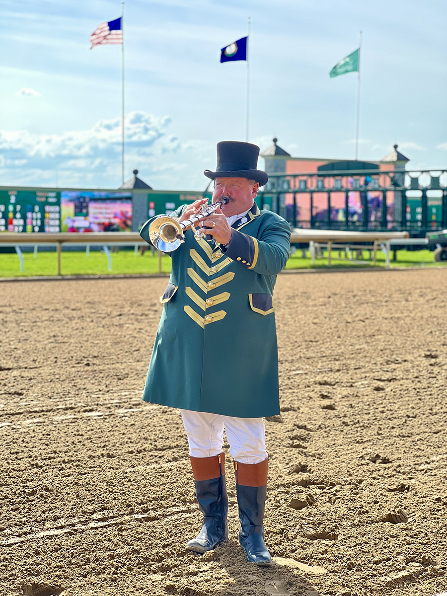 man playing trumpet at horse races